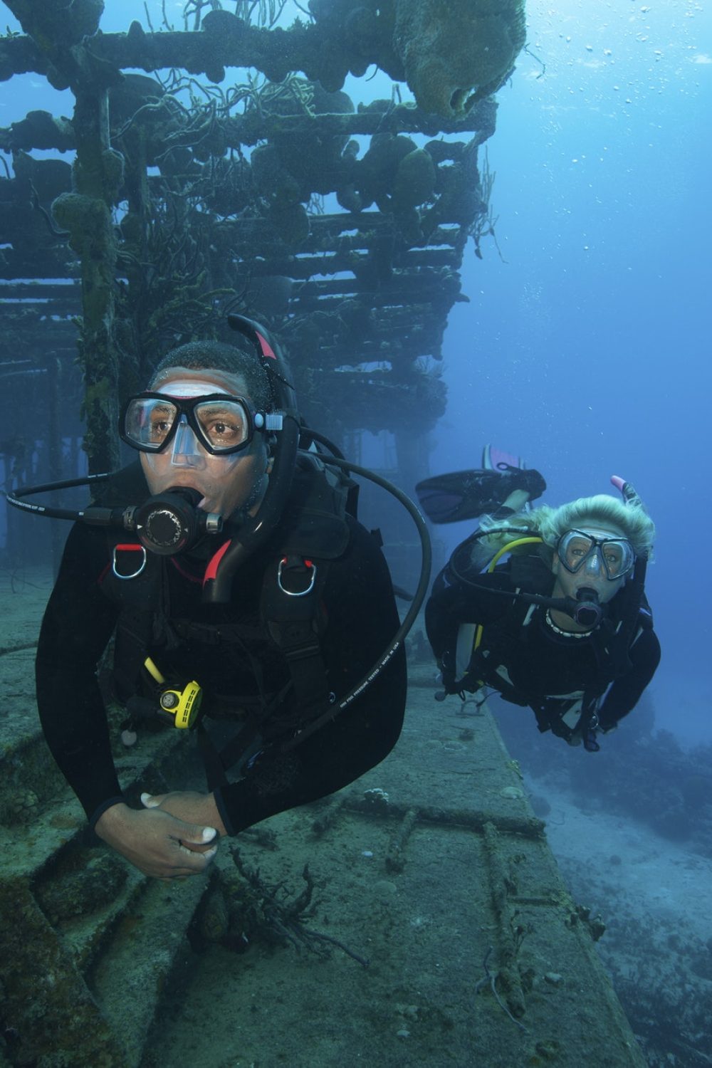 two-divers-swimming-along-the-remaining-structure-of-a-shipwreck-.jpg